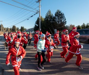 Runners in Santa suits running on the street in Kennebunk, Maine