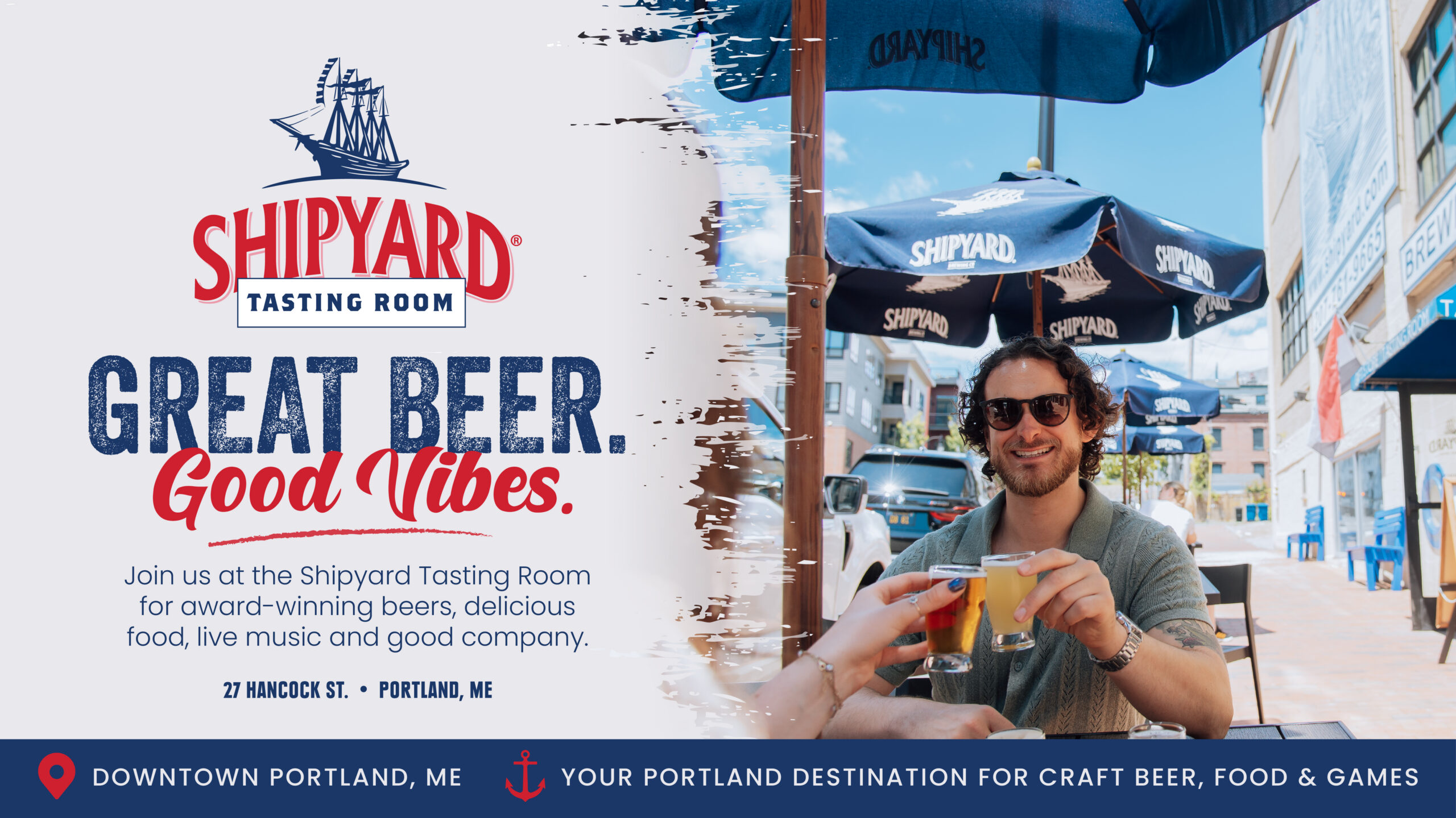 A man enjoys a beer at an outdoor table under Shipyard umbrellas. The sign reads, "Shipyard Tasting Room: Great Beer. Good Vibes.” with details about the tasting room and its Portland, ME location.